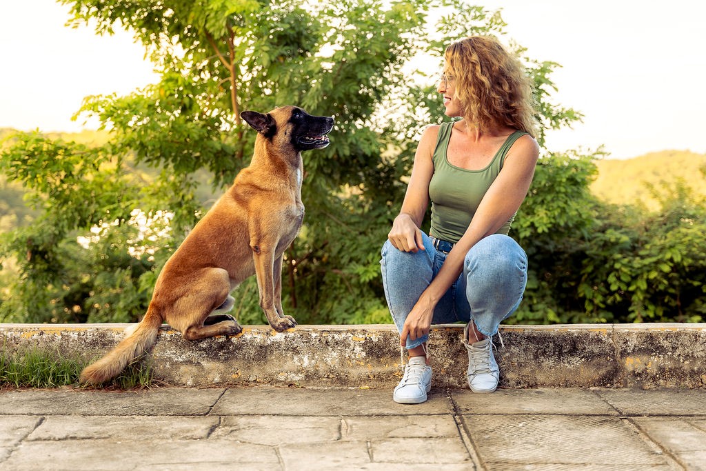 Trainer and her dog sharing a trusting moment at golden hour